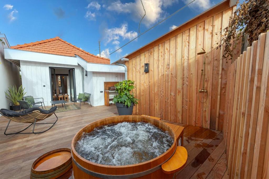 d'un bain à remous sur une terrasse dotée d'un mur en bois. dans l'établissement Bulle marine, à Andernos-les-Bains