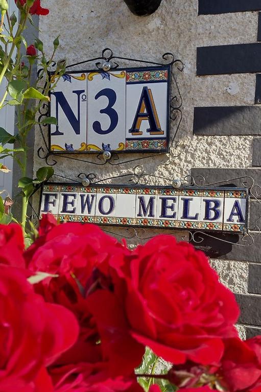 a street sign on the side of a building with red roses at Ferienwohnung Melba in Traben-Trarbach