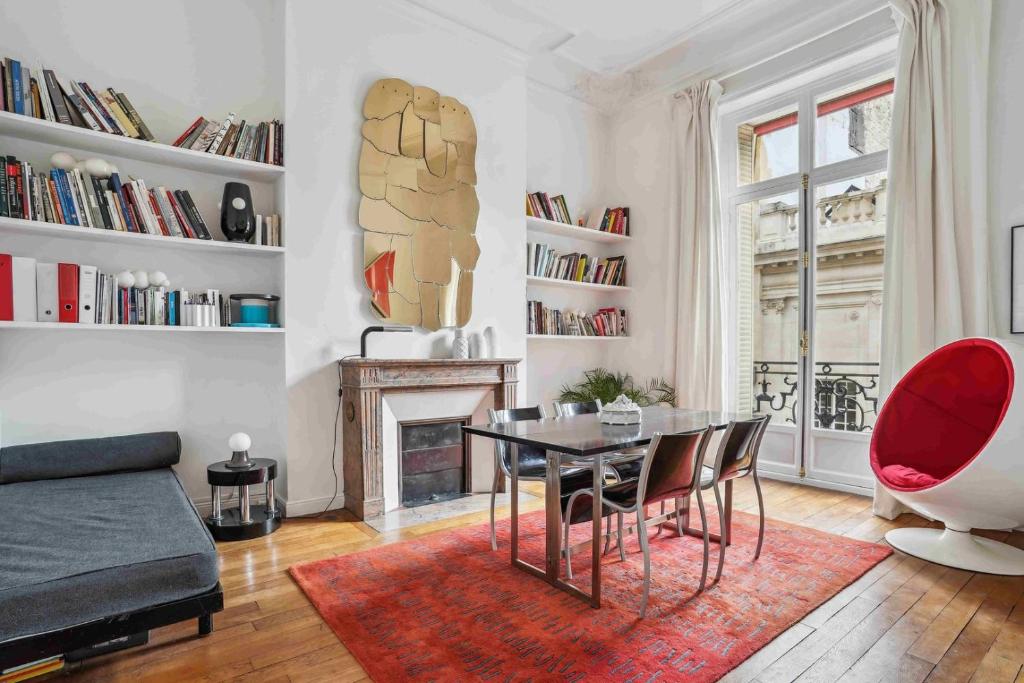 un salon avec une table et des chaises et une cheminée dans l'établissement Le Fabuleux au coeur de Paris, à Paris
