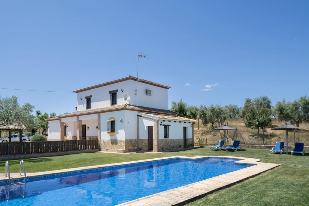 a villa with a swimming pool in front of a house at La Pedrosa in La Cimada
