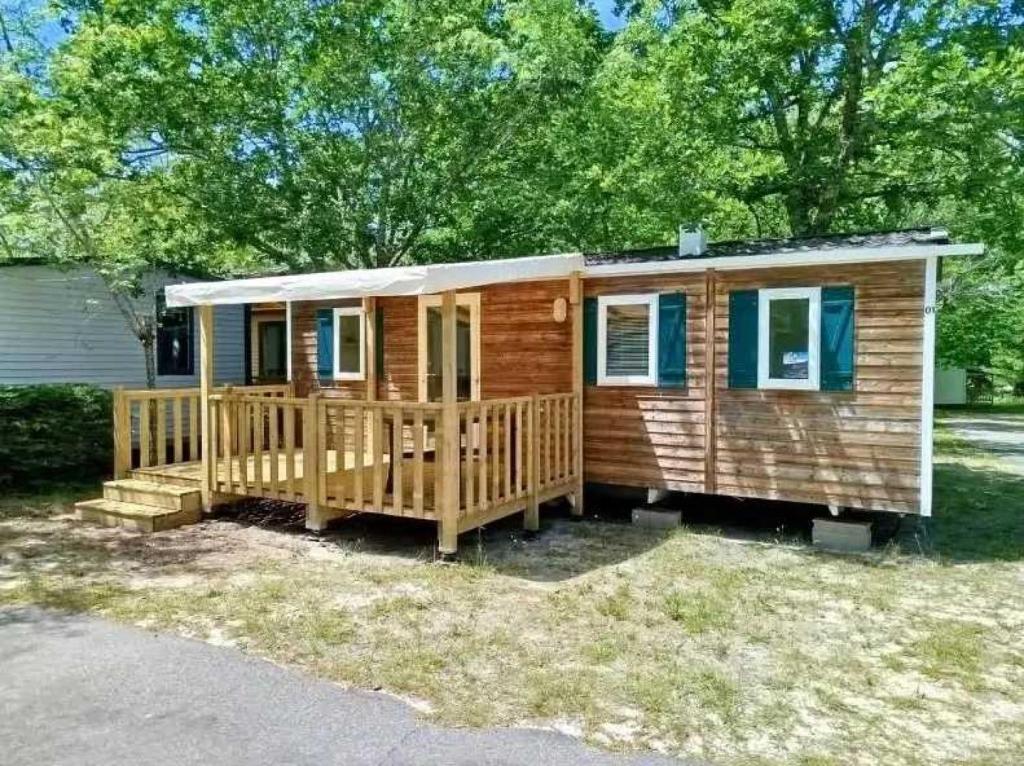 Ce chalet en bois dispose d'une véranda et d'une terrasse. dans l'établissement Camping - Piscine - eechfc, à Mézos