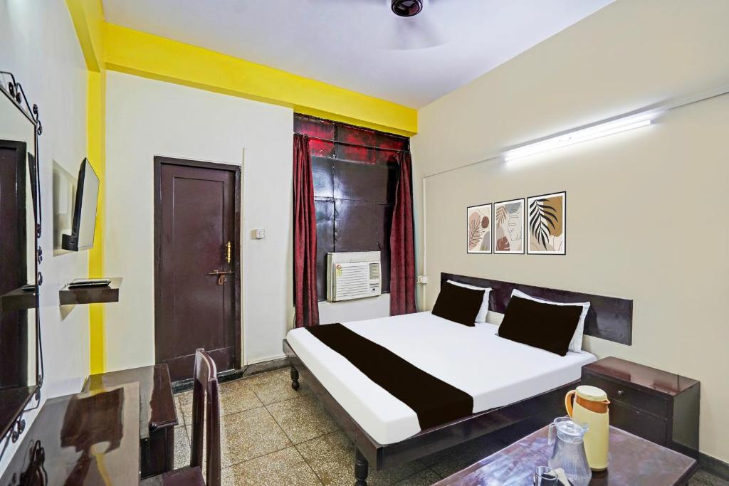 una habitación de hotel con una cama y una mesa en Hotel O Raj Mahal, en Kānpur