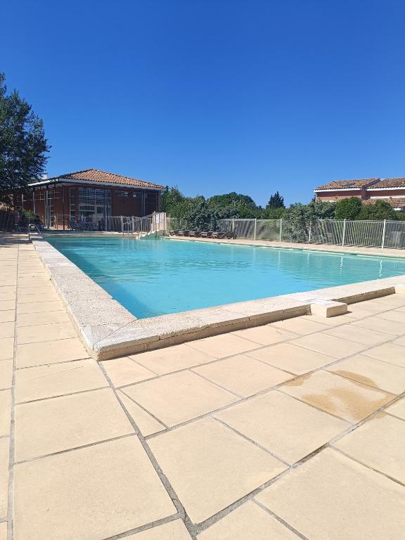 une grande piscine avec de l'eau bleue dans l'établissement La Cigale d'Avignon, à Saint-Saturnin-lès-Avignon