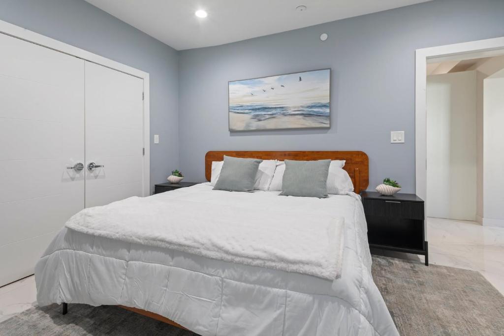 a white bedroom with a large bed with a wooden headboard at Ammos Luxury Living- Naxos Suite in Ventnor City
