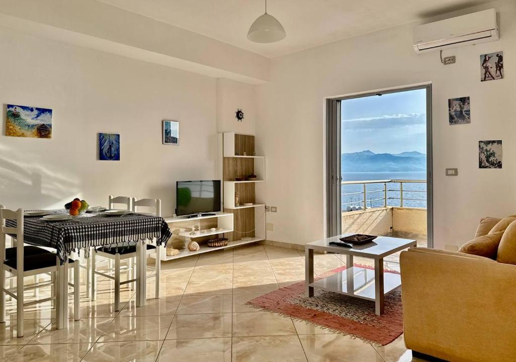 un soggiorno con un tavolo e una televisione di Corfu View Apartment a Sarandë