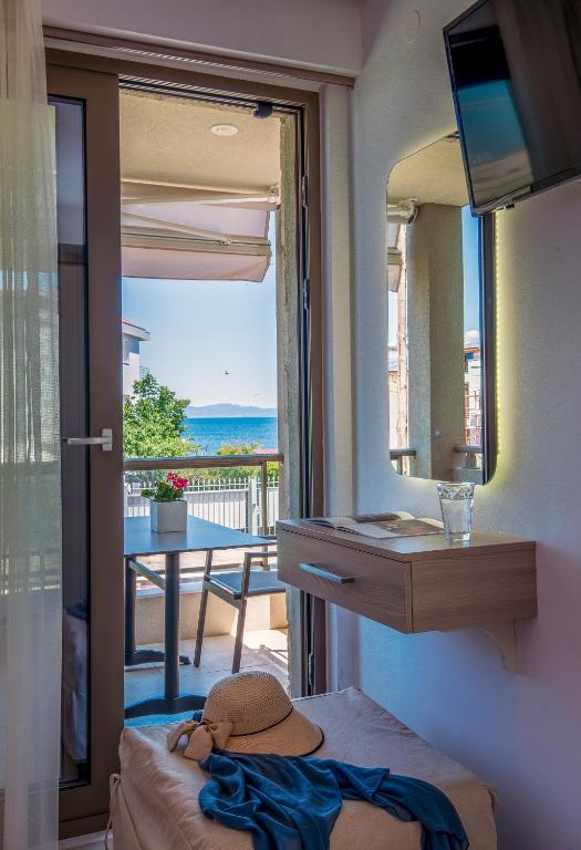 a bedroom with a view of the ocean from a balcony at Marthina Luxury Living in Nea Potidaea