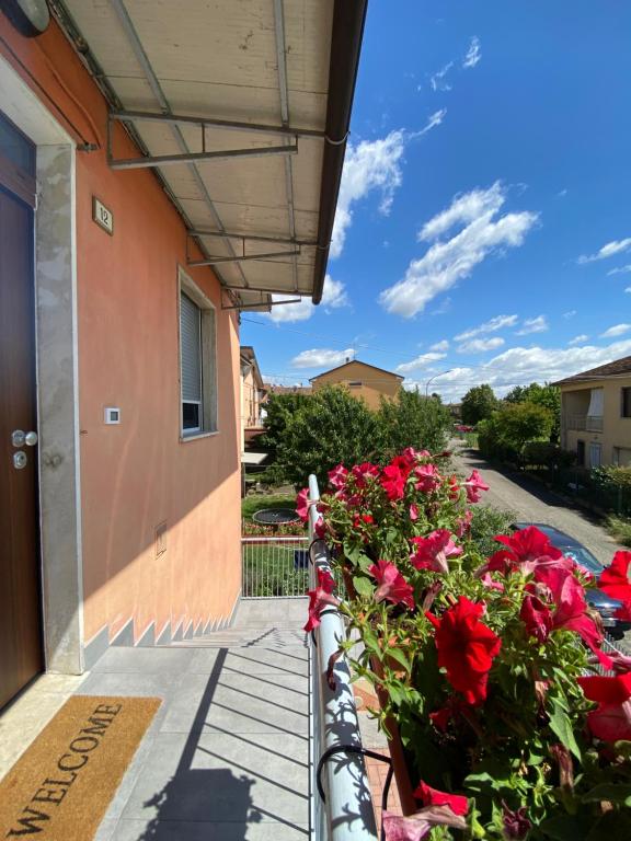 un balcón con rosas rojas en un edificio en Apartment Caorso Rino, en Caorso