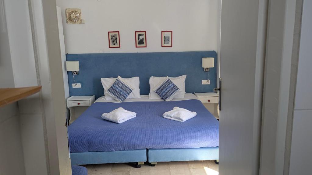 a bedroom with a blue bed with two pillows at Coral in Frangokastello