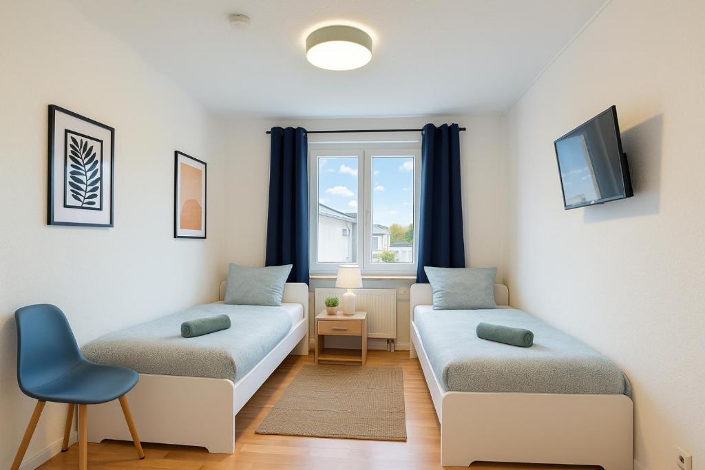 Una sala de estar con dos camas y una ventana. en StayInn Halle (Saale), en Nietleben