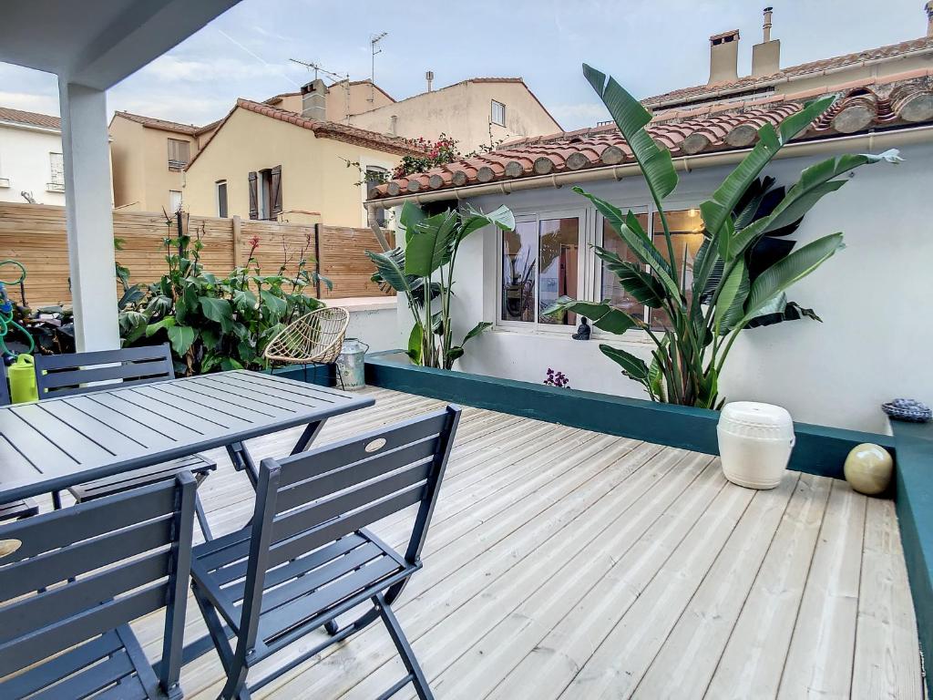 une terrasse en bois avec une table et des chaises sur une maison dans l'établissement RDC a 2 pas du port, à Port-Vendres