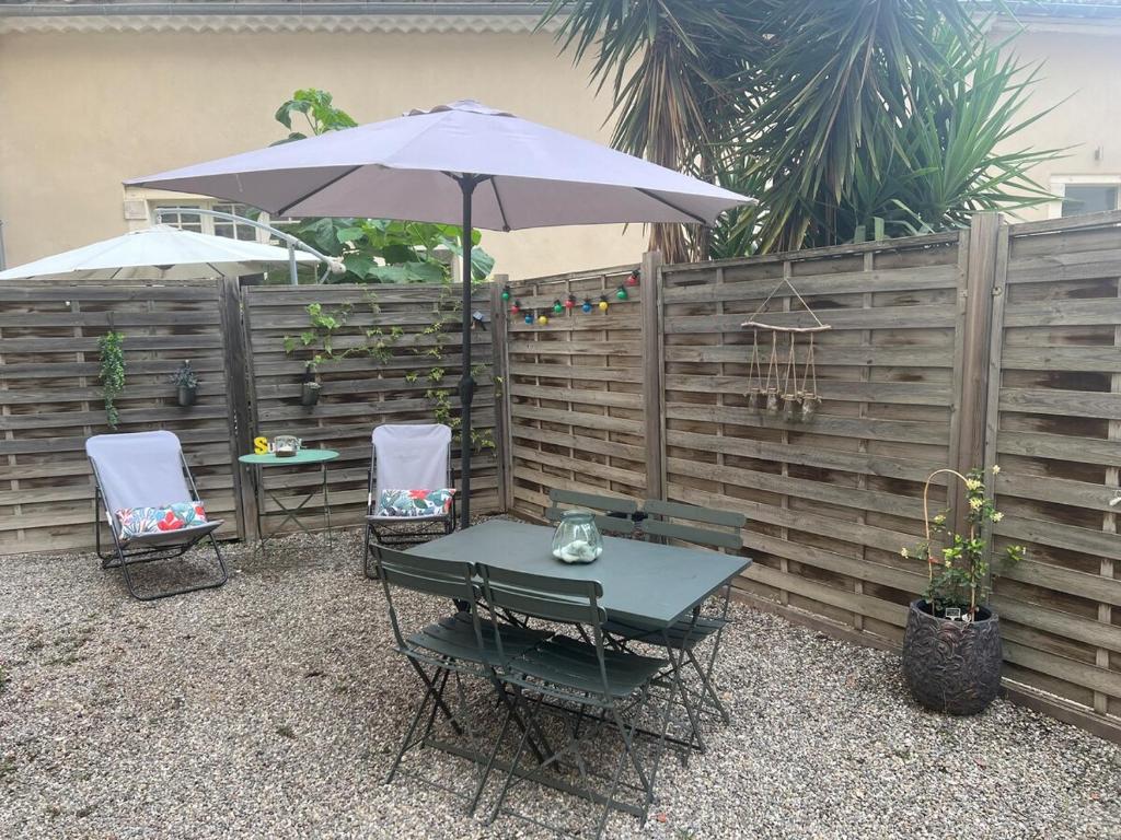 un patio avec une table, des chaises et un parasol dans l'établissement Beautiful F2 with large terrace & air conditioning, à Avignon
