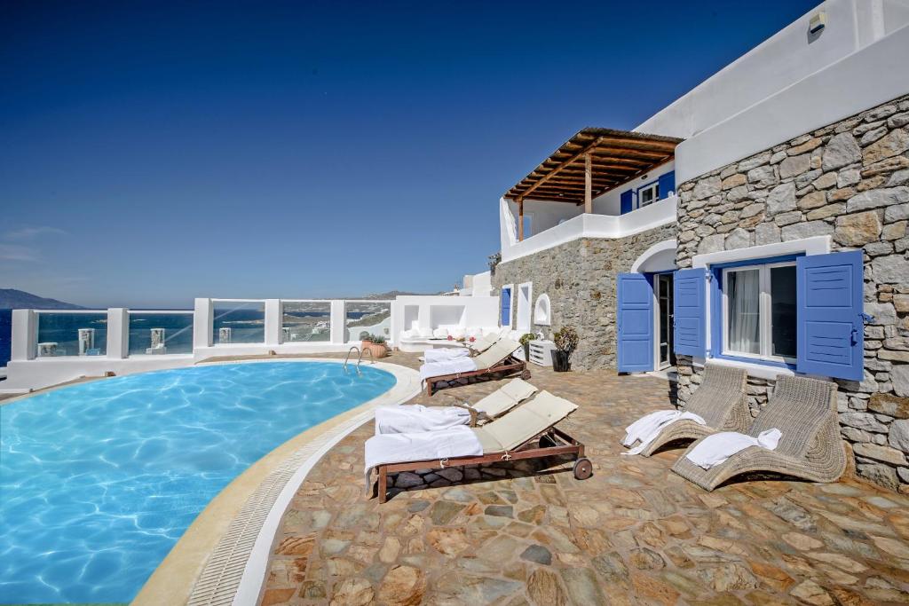 a villa with a swimming pool in front of a house at Mykonos Art Villa in Mikonos