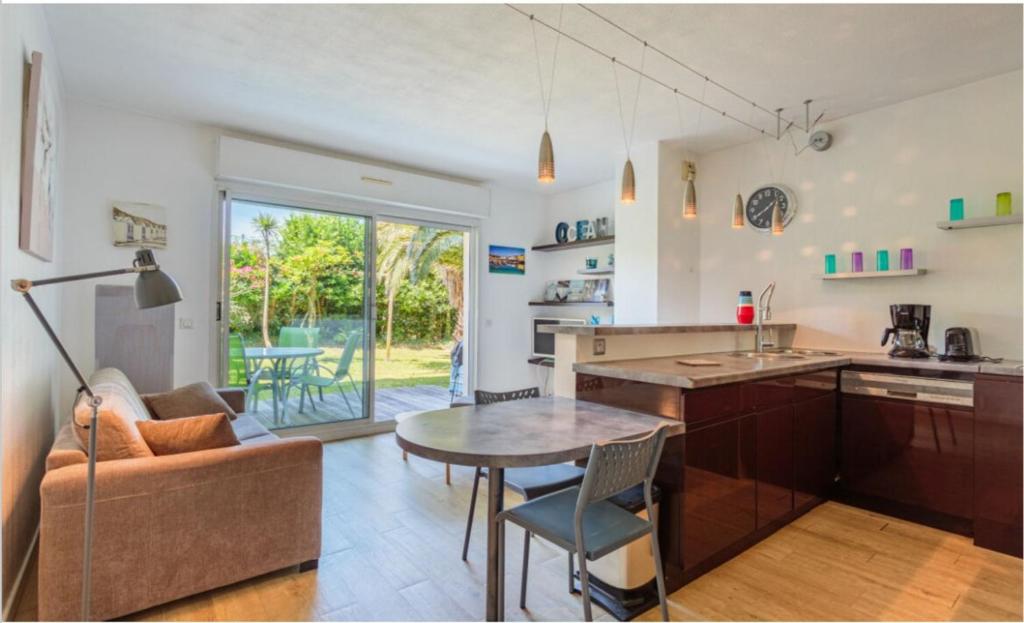 une cuisine et un salon avec une table et un canapé dans l'établissement Location Appartement avec Jardin Anglet Chiberta, à Anglet