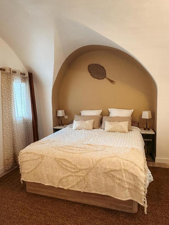 - une chambre avec un grand lit et une arche au-dessus dans l'établissement Cosy Cœur Alpilles, T2 neuf, à Aureille