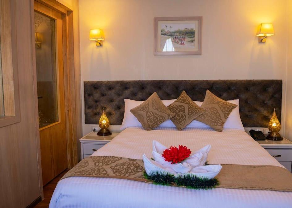 a bedroom with a large bed with two flowers on it at دهبيه كوين شارلوت in Luxor