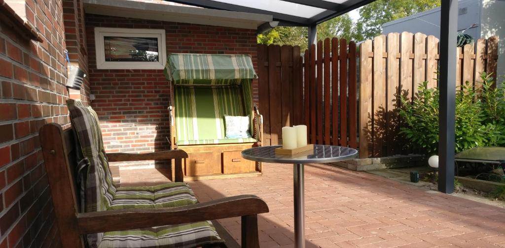 a patio with a table and a candle on it at Apartment an der Fehnroute in Leer