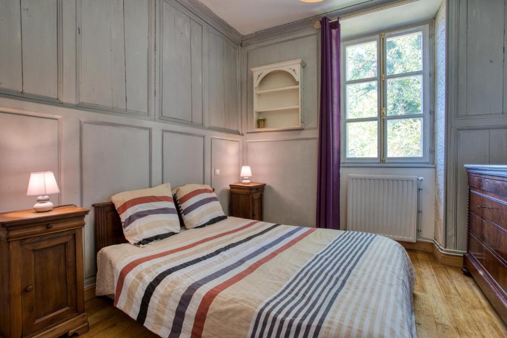 - une chambre avec un lit avec deux lampes et deux fenêtres dans l'établissement La Petite Cour, à Mayac