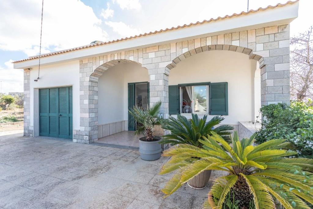 ein Haus mit grüner Tür und einigen Pflanzen in der Unterkunft Villetta Marika - Salento Reservation in Marina di Mancaversa
