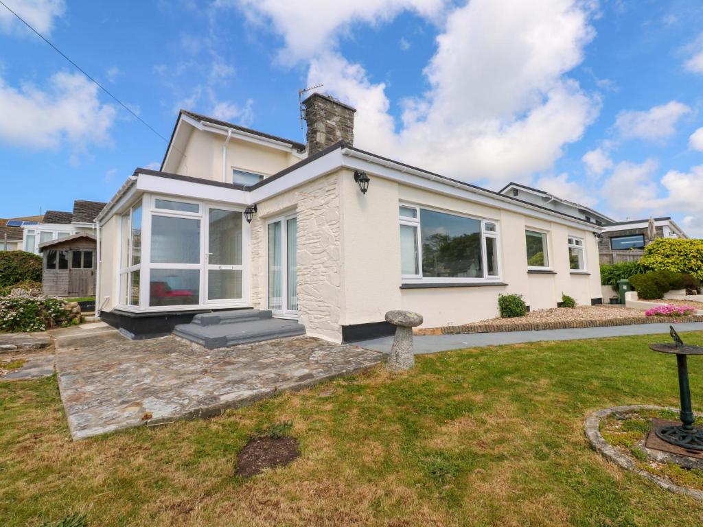 een wit huis met een gazon ervoor bij Karenza in Penzance