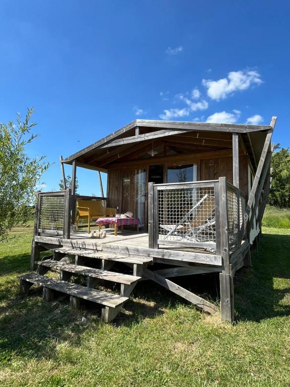 a small wooden shack with a porch on the grass at Camping Chambord in Mont-près-Chambord