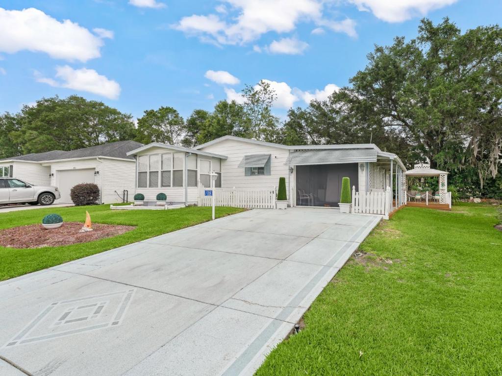 a house with a driveway in a yard at 1705 Z1 Village of Orange Blossom Gardens by REMAX Premier in The Villages