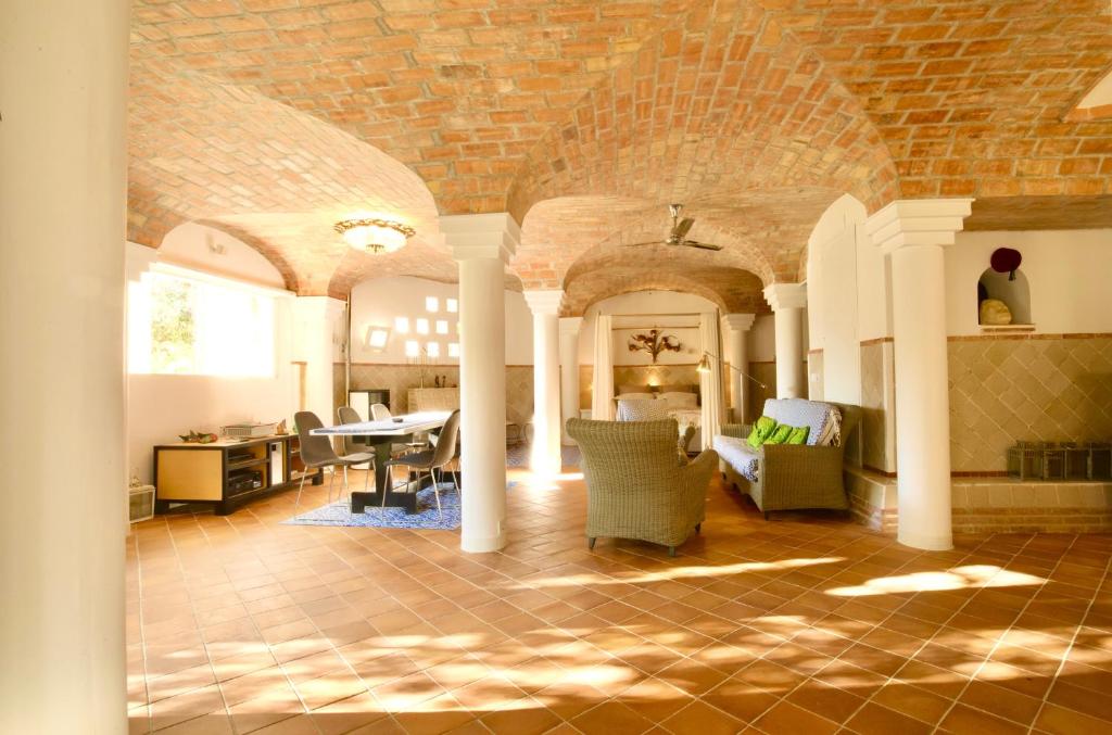 un soggiorno con muro di mattoni, tavolo e sedie di Melegis 1-Bed Cottage Sleeps 2 Pool & Garden a Melegis
