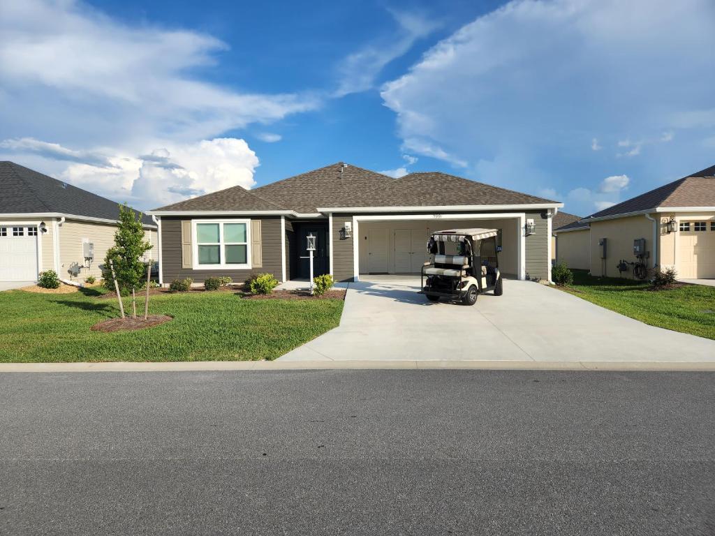 a house with a golf cart parked in the driveway at 3 Bedroom 2 Bath Designer in The Villages