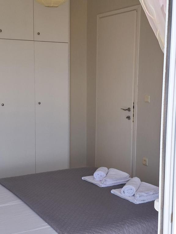 una camera con due letti con specchi e asciugamani di E&M Villa See View a Polykhrono