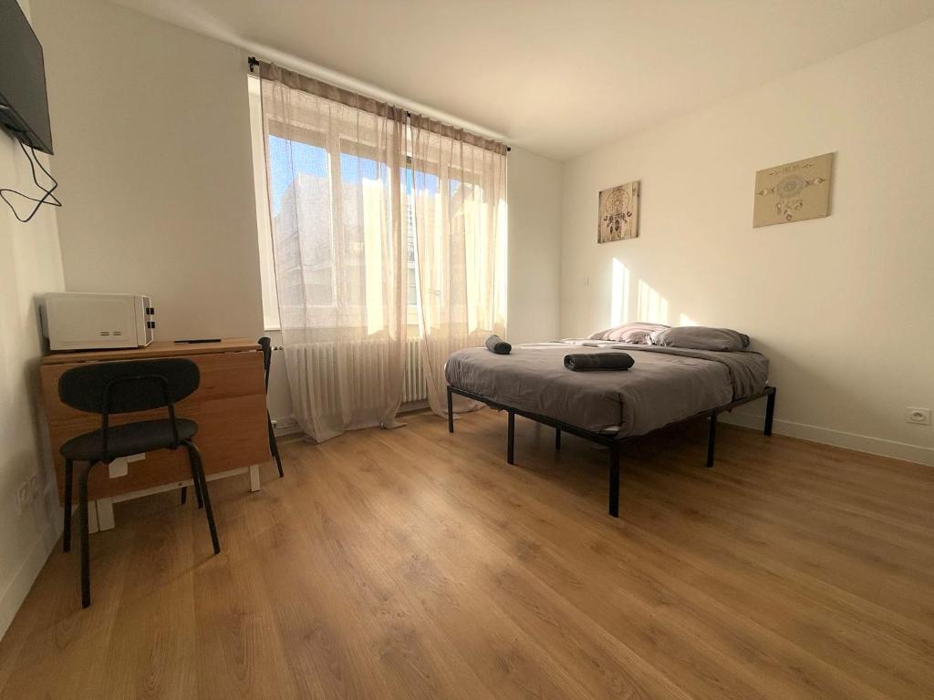 une chambre avec un lit, un bureau et une fenêtre dans l'établissement M28 Marquer joli appartement proche de la gare et du centre ville, à Annemasse