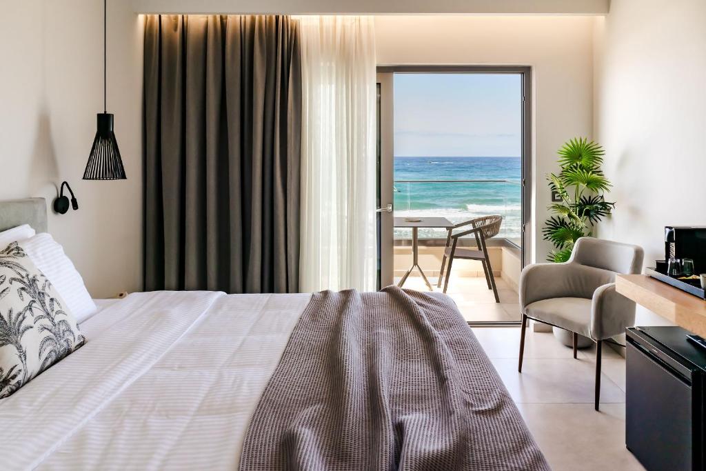 sypialnia z łóżkiem i widokiem na ocean w obiekcie Batis Beach Hotel w Retimnie