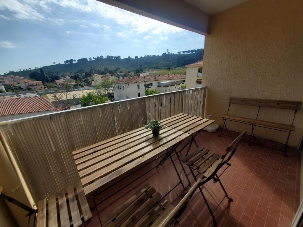 d'une table et de chaises en bois sur un balcon avec vue. dans l'établissement Grand T3 tout équipé au cœur du village, à Saint-Mandrier-sur-Mer