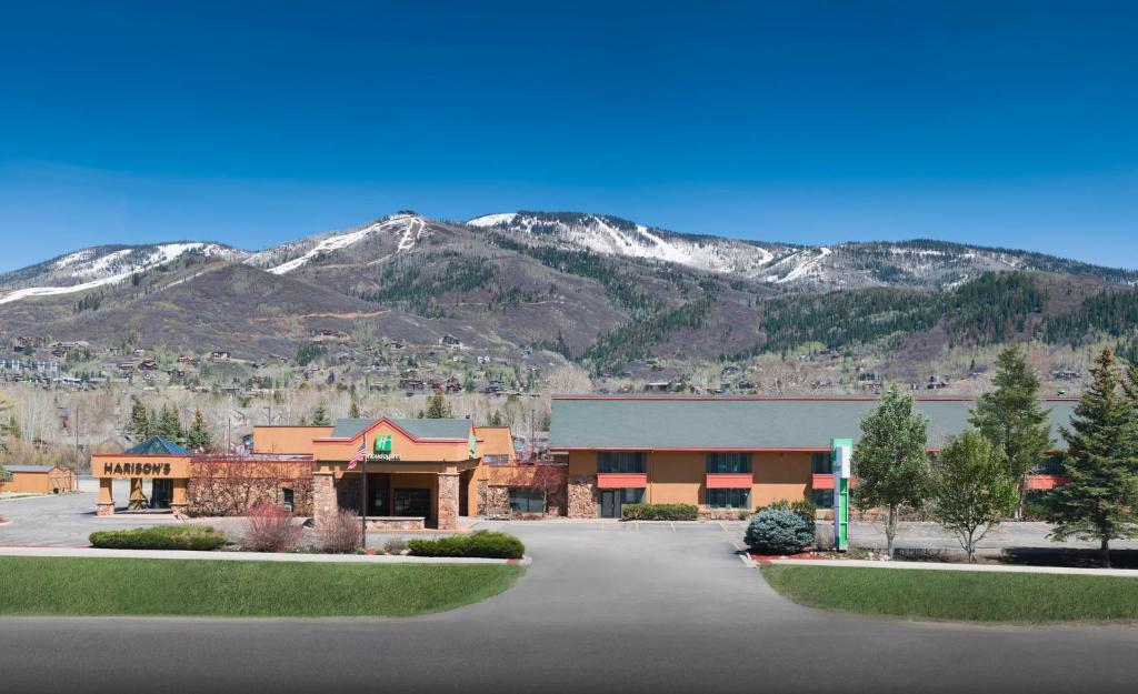 a large building with mountains in the background at Holiday Inn Steamboat Springs by IHG in Steamboat Springs