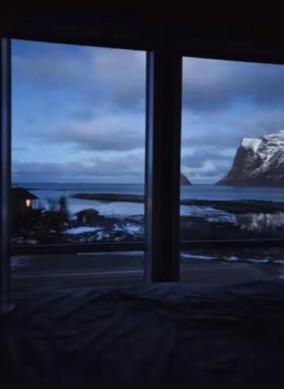 a window with a view of the ocean and a mountain at Explorers Cabin Lofoten in Offersøya