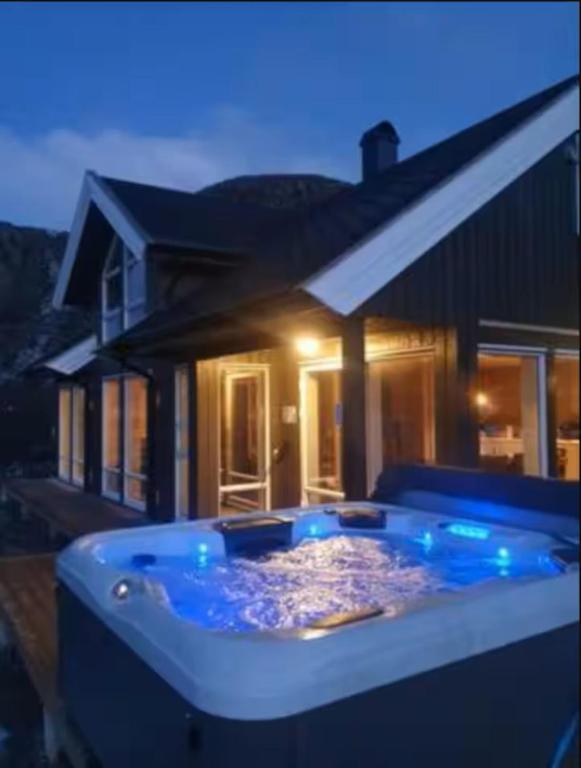 a large hot tub in front of a house at Explorers Cabin Lofoten in Offersøya