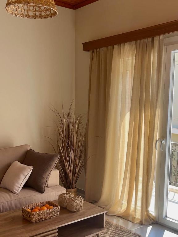 a living room with a couch and a window at Louloudi Apartment in Tsilivi