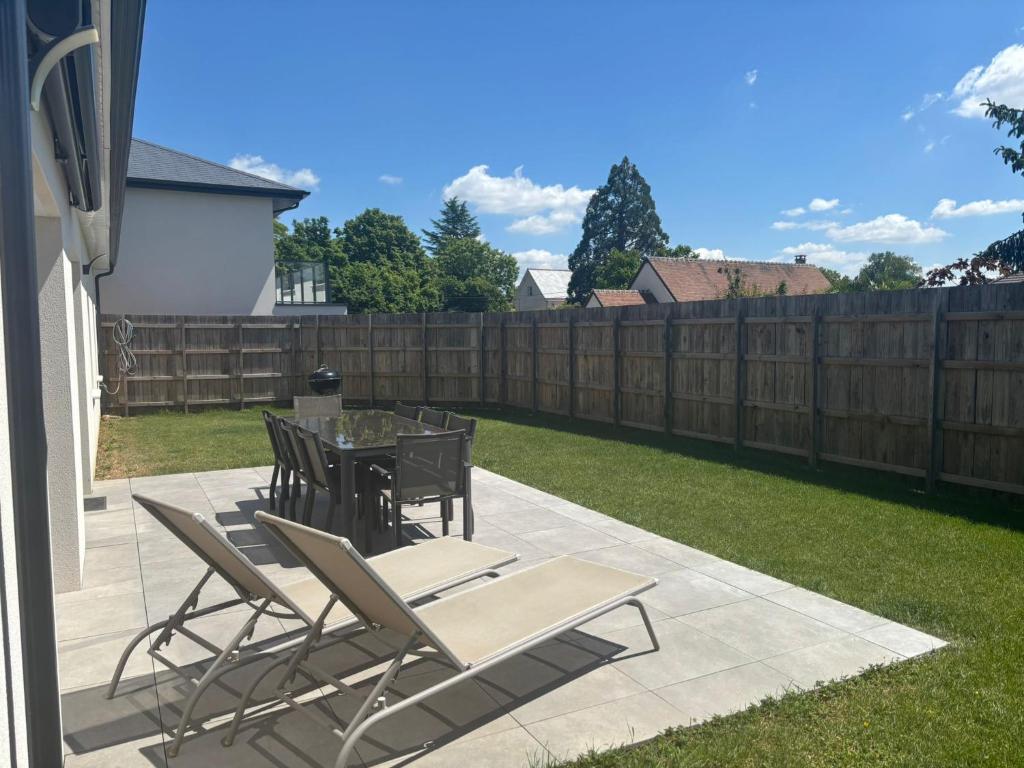 a patio with a table and chairs and a fence at La Villa Coquette in Vouvray