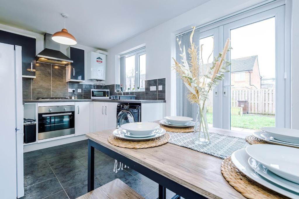 una cucina con tavolo in legno e piatti di Steps from O2 Apollo, Ox road a Manchester