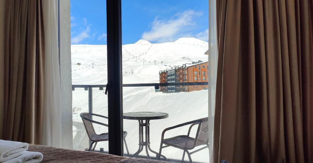 a room with a view of a snowy mountain from a window at GVC New Gudauri Twins 413 Mountain View in Gudauri
