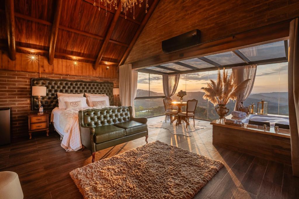 a bedroom with a bed and a couch and a window at Morada Valente in Gramado