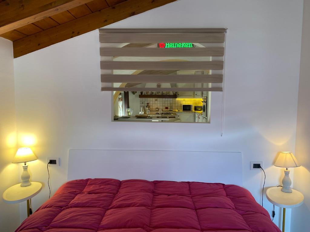 a bedroom with a red bed and two lamps at Casa Mauro in Gravedona
