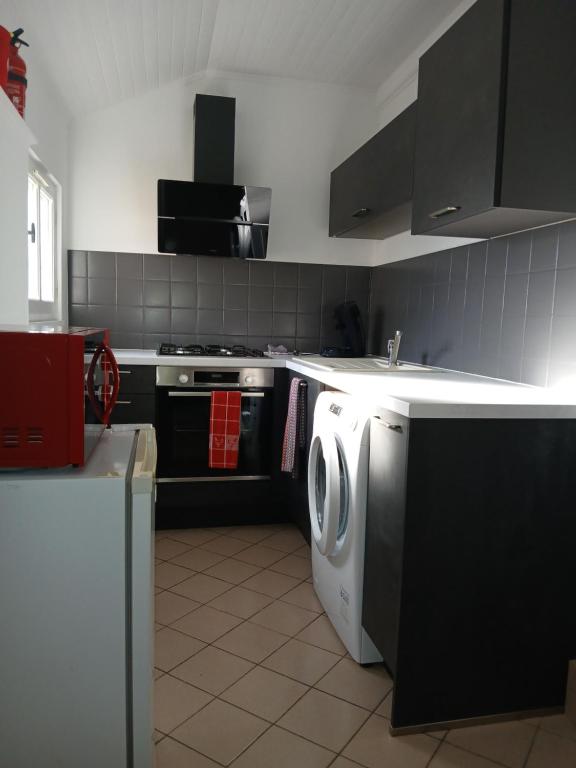 a kitchen with a washing machine and a sink at gîte in Malafretaz