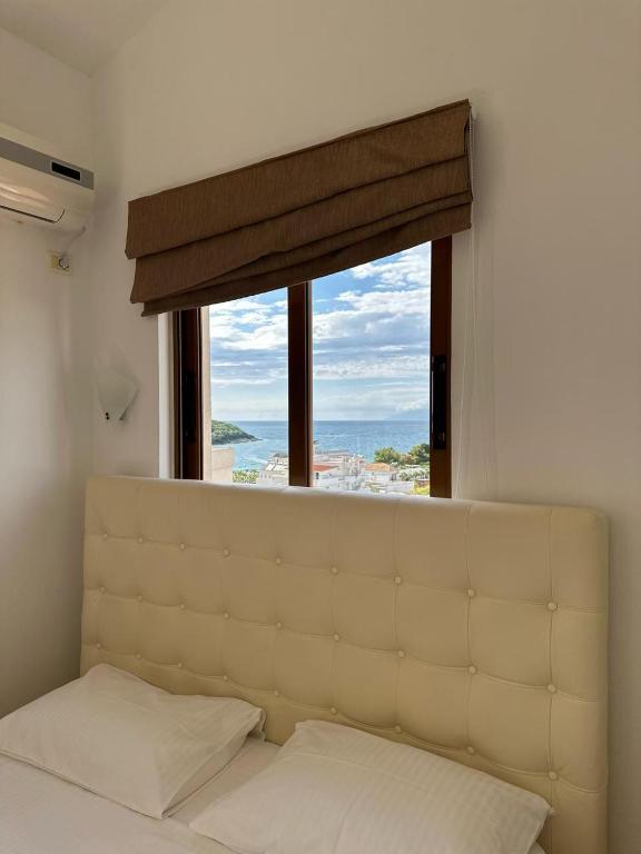 a bedroom with a large window above a bed at Hotel Marku in Ksamil