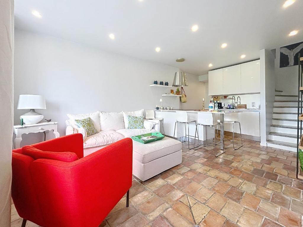 a living room with a red couch and a kitchen at Les Verdalettes Beautiful view in Saint Paul de Vence
