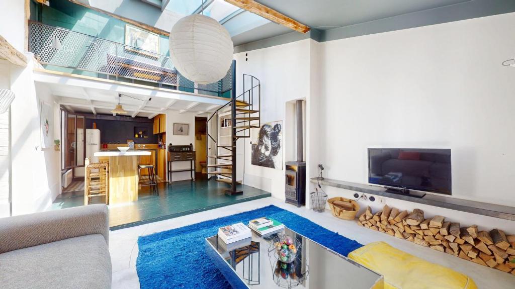 un salon avec un tapis bleu et un salon avec une cheminée dans l'établissement Charming Loft Apartment by Canal Saint Martin, à Paris