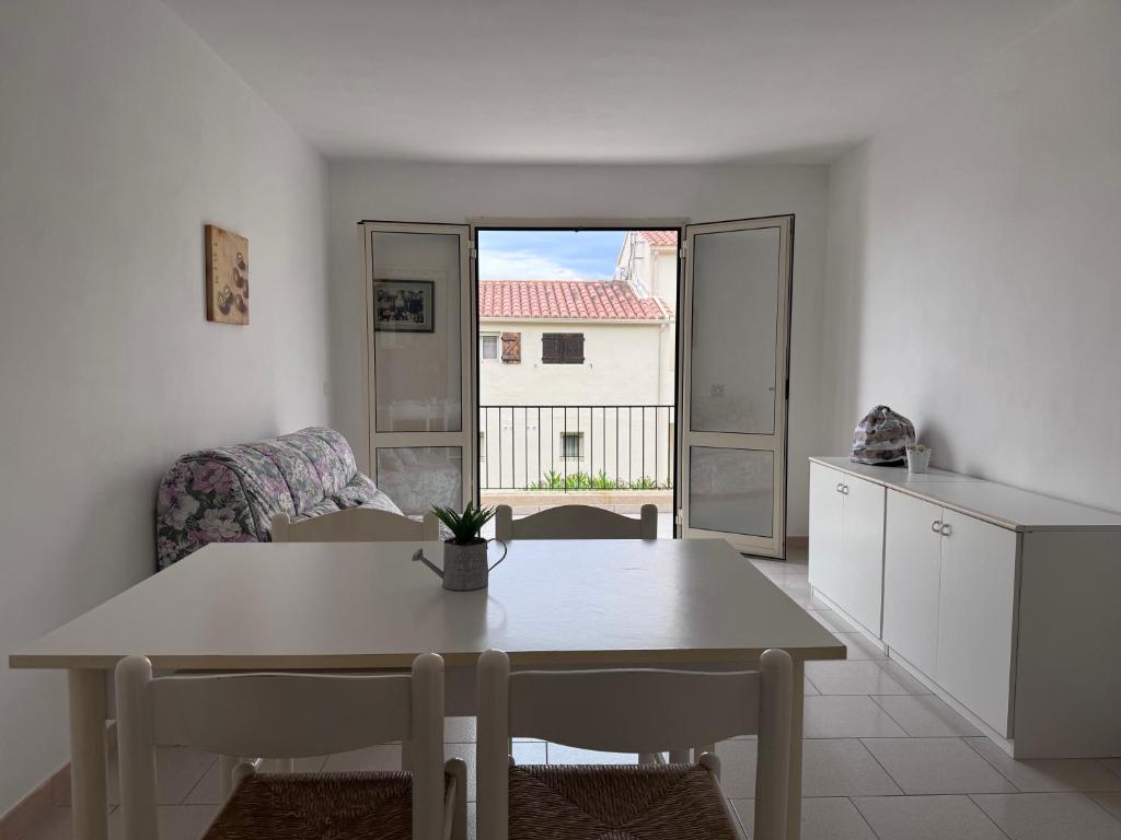 un salon avec une table et une cuisine dans l'établissement I Certali apt 5 apt 6, à LʼÎle-Rousse