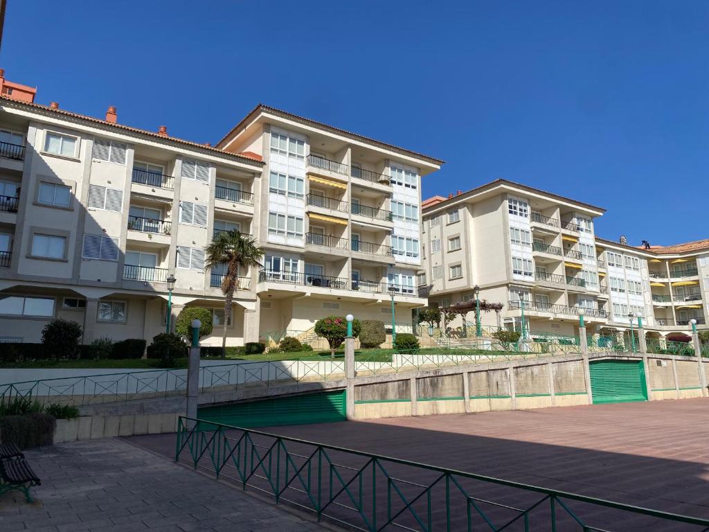 una fila de edificios de apartamentos junto a una acera en Playa Panxón Mar, en Nigrán