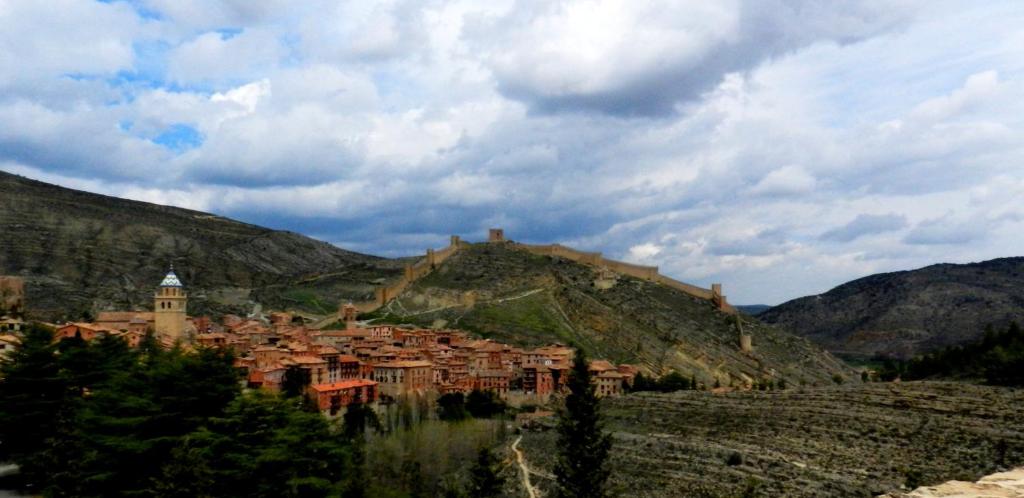 a town on top of a hill in the mountains at Apartamentos El Brezo in Albarracín
