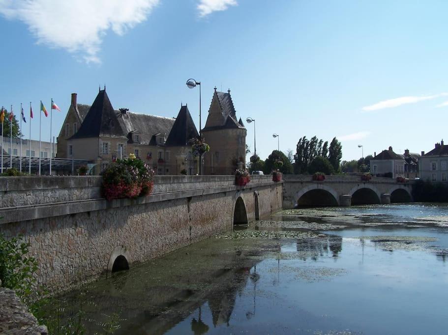 un pont sur une rivière dans une ville avec des bâtiments dans l'établissement La Maison de Valérie, à La Flèche