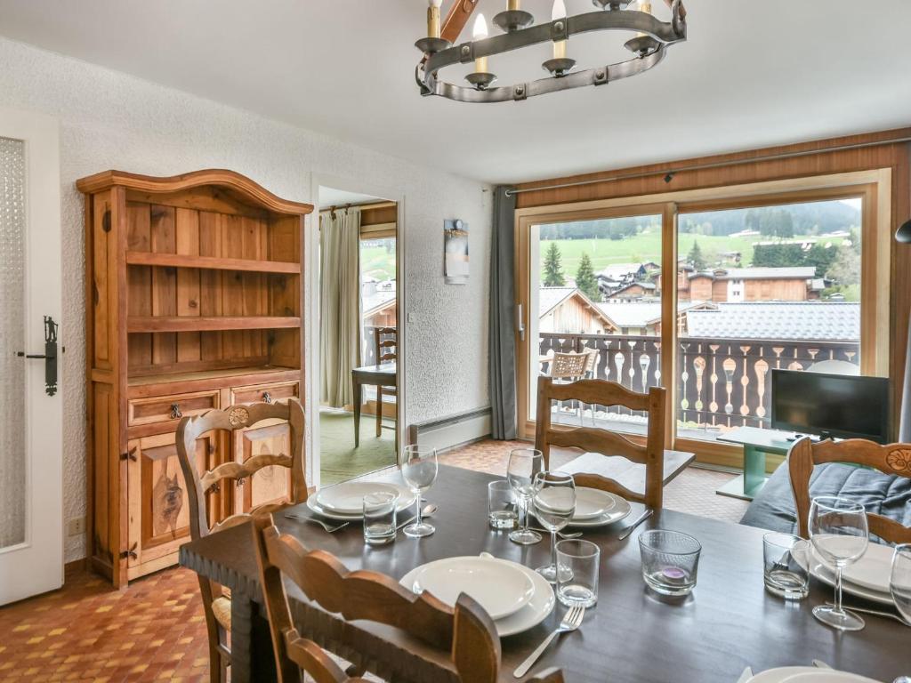 une salle à manger avec une table et un balcon dans l'établissement Appartement 1 chambre, proche centre, parking et équipements modernes - FR-1-685-82, aux Gets