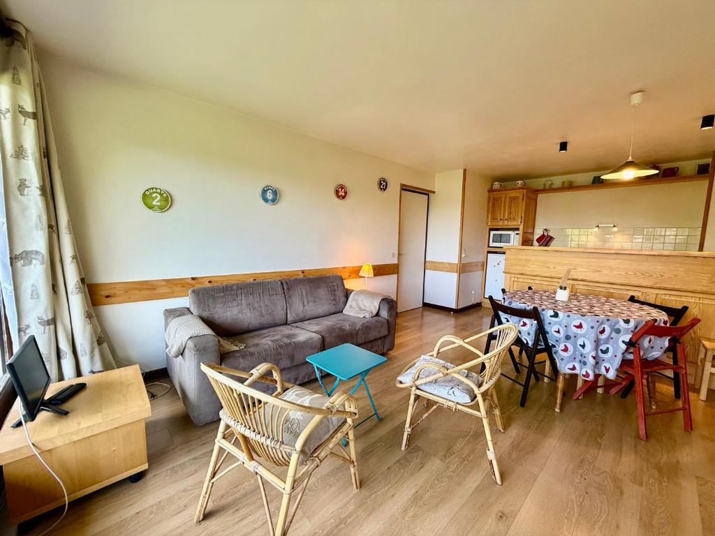 un salon avec un canapé, une table et des chaises dans l'établissement Appartement au pied des pistes, proche commodités, balcon, parking, calme - FR-1-505-8, à Notre-Dame-de-Bellecombe